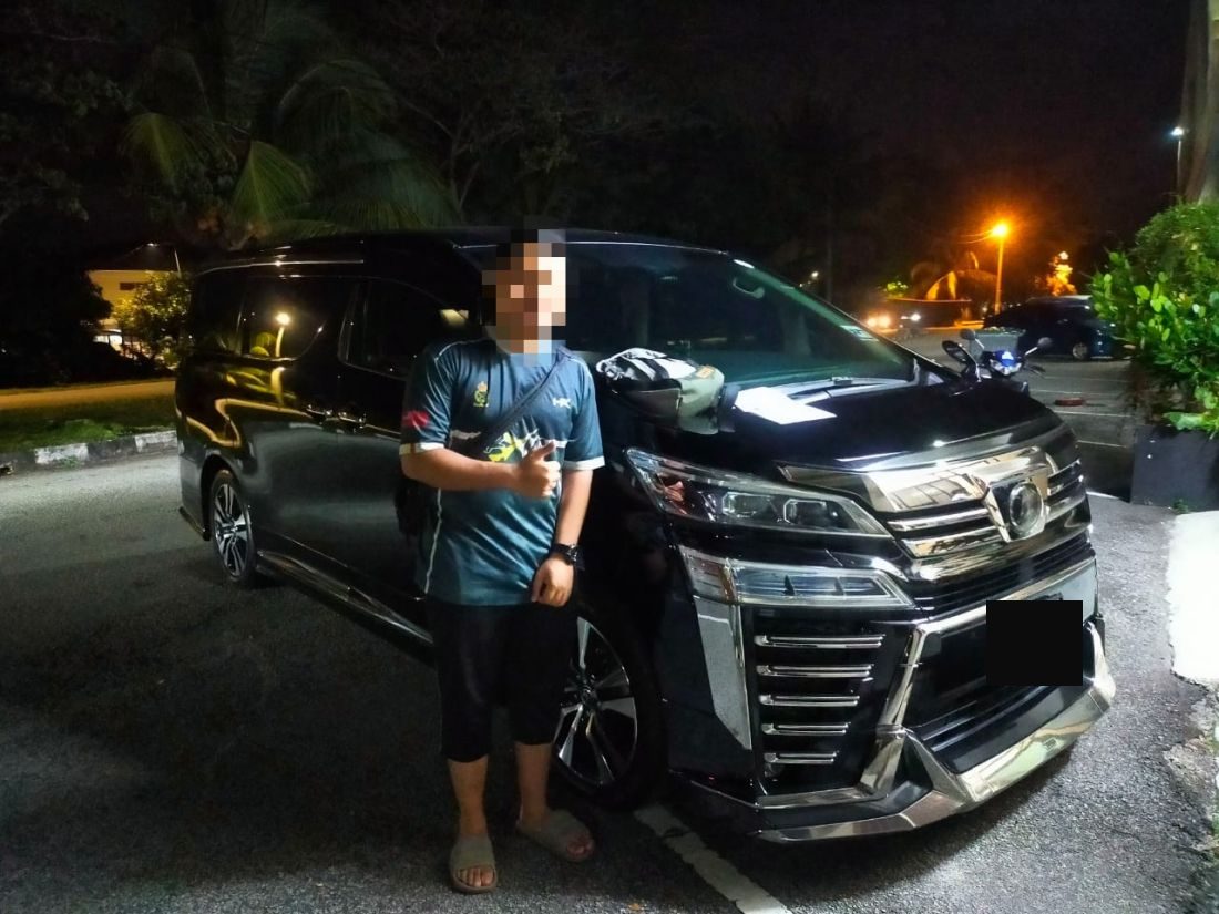 Customer giving a thumbs up next to the Vellfire at night