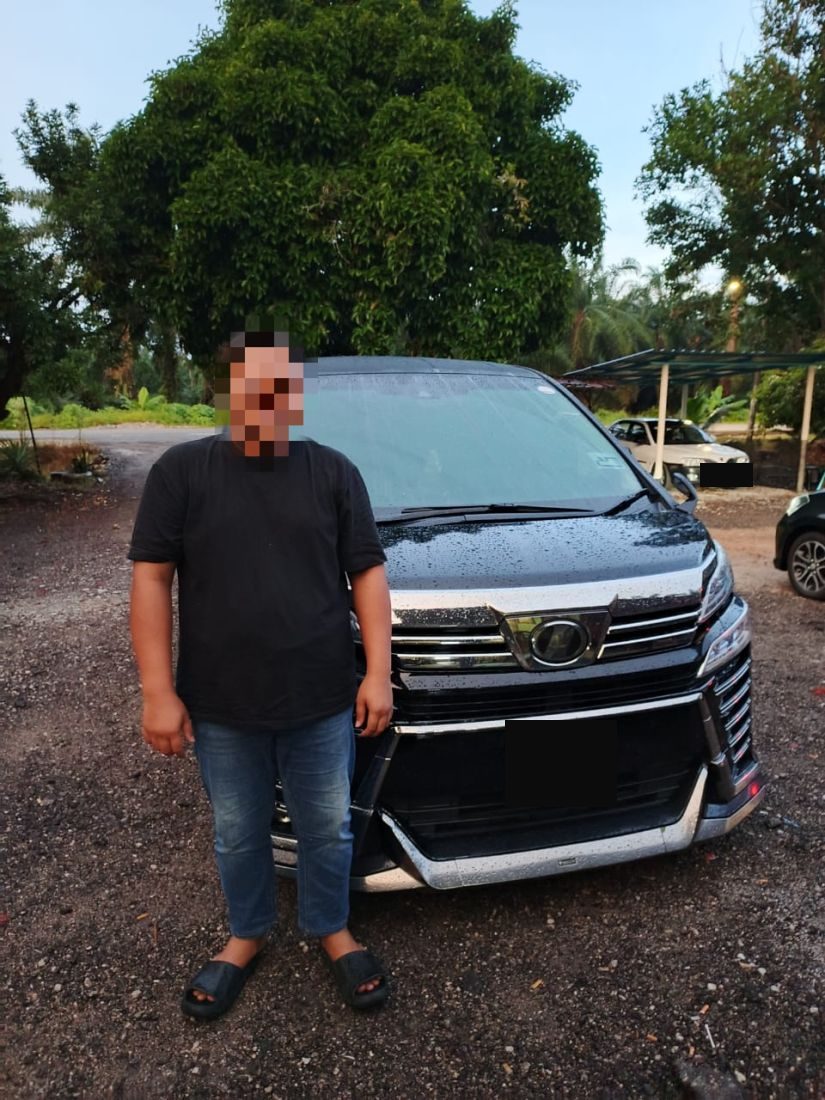 Customer standing beside the Vellfire at a kampung house